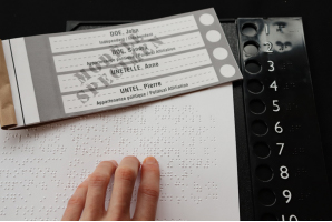 Électeur lisant un bulletin de vote en braille