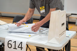 Préposé au scrutin servant un électeur