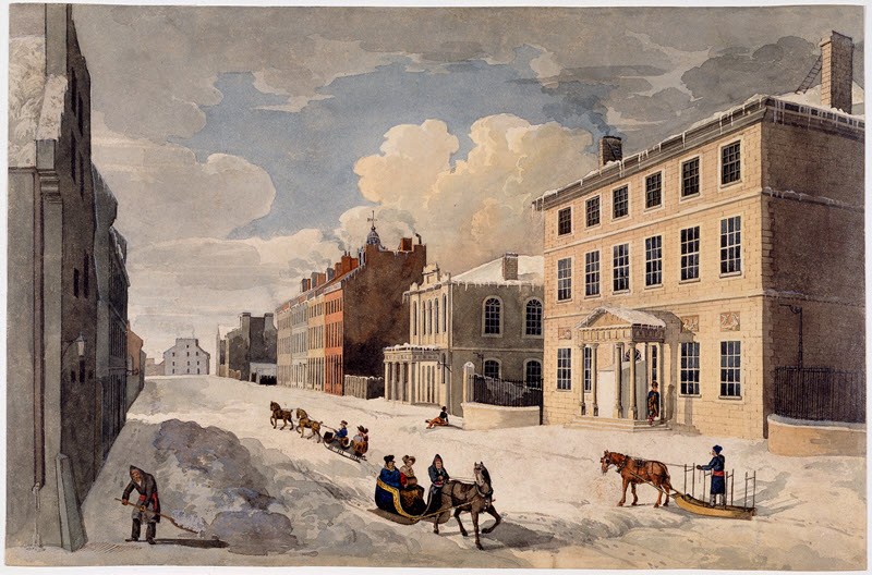Watercolour painting of Montréal's St. James Street during the winter of 1825. At the bottom left, a man is shoveling snow. In the centre, people are riding in horse-drawn sleighs along the snowy street.
