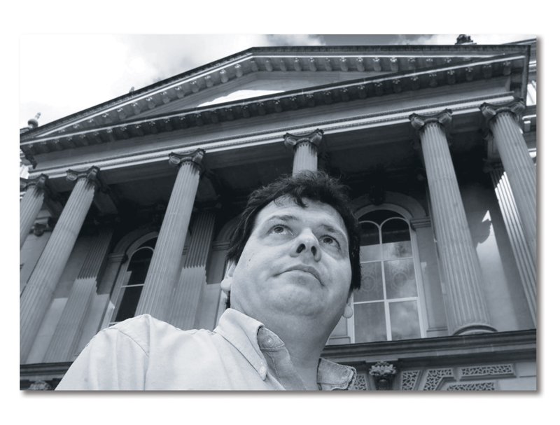 Photo Miguel Figueroa, from the shoulders up, in front of a courthouse with large pillars.